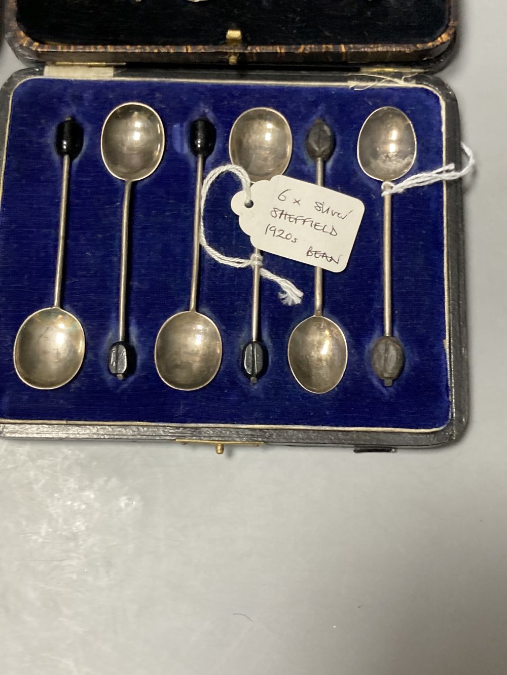 Twelve Victorian silver Apostle coffee spoons and sugar tongs, and three sets of six silver bean end coffee spoons, all cased